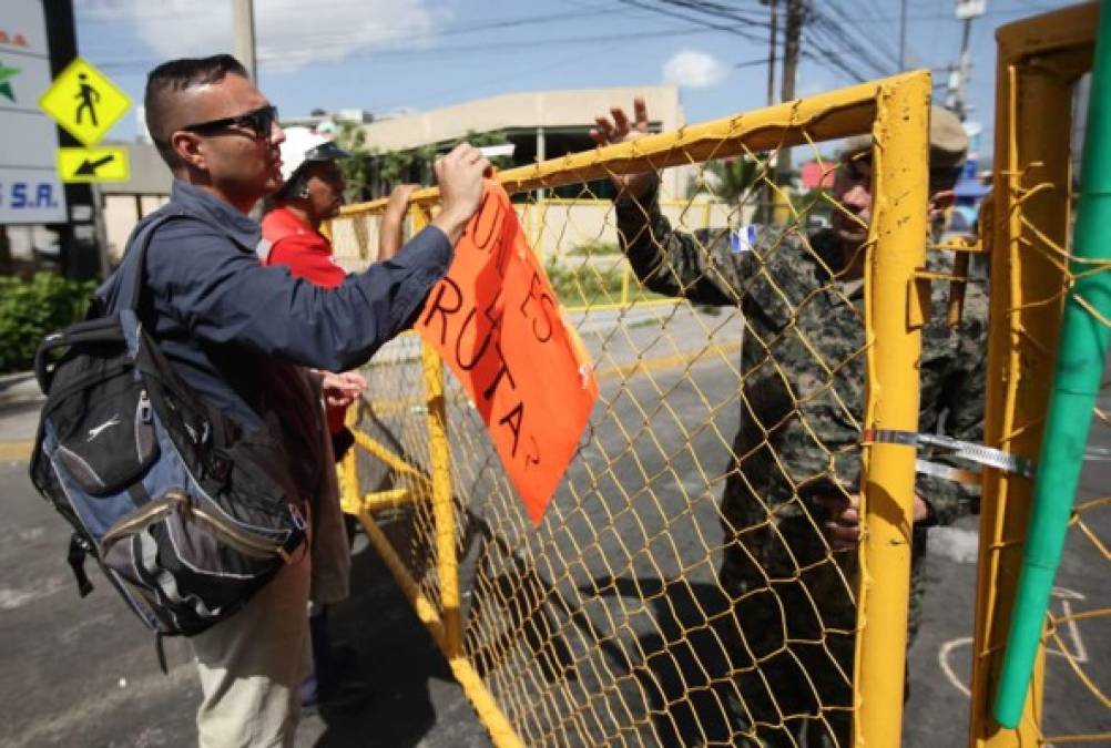 Un manifestante pone una pancarta en las vallas de la Policía Nacional.