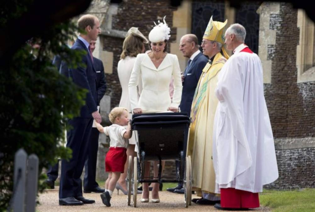 Simpática imagen del pequeño George poniéndose de puntillas en el carrito para asomarse a ver a su hermanita.