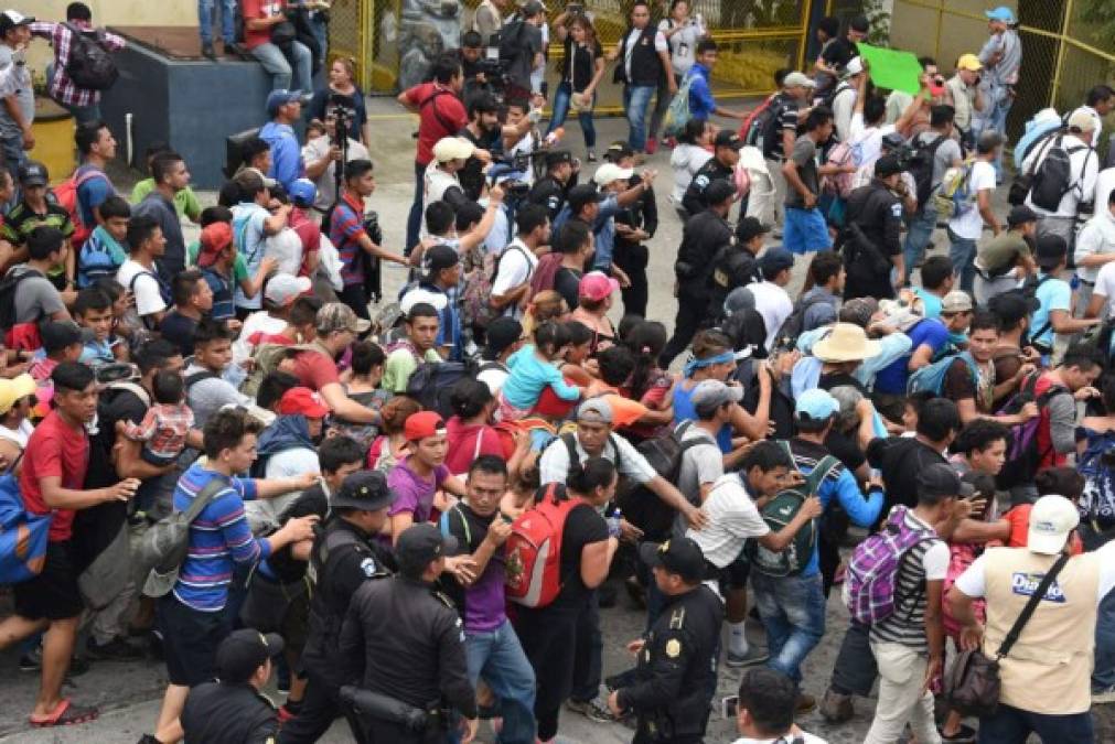 Los hondureños también lograron abrir y doblar un portón metálico que impedía el paso hacia la frontera. Foto AFP