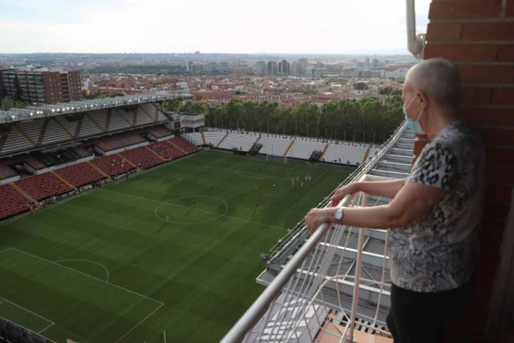 Unq aficionadq ataviadq con mascarilla, presencia desde el balcón de su domicilio, el encuentro de Segunda División entre el Rayo Vallecano y el Albacete Balompié.