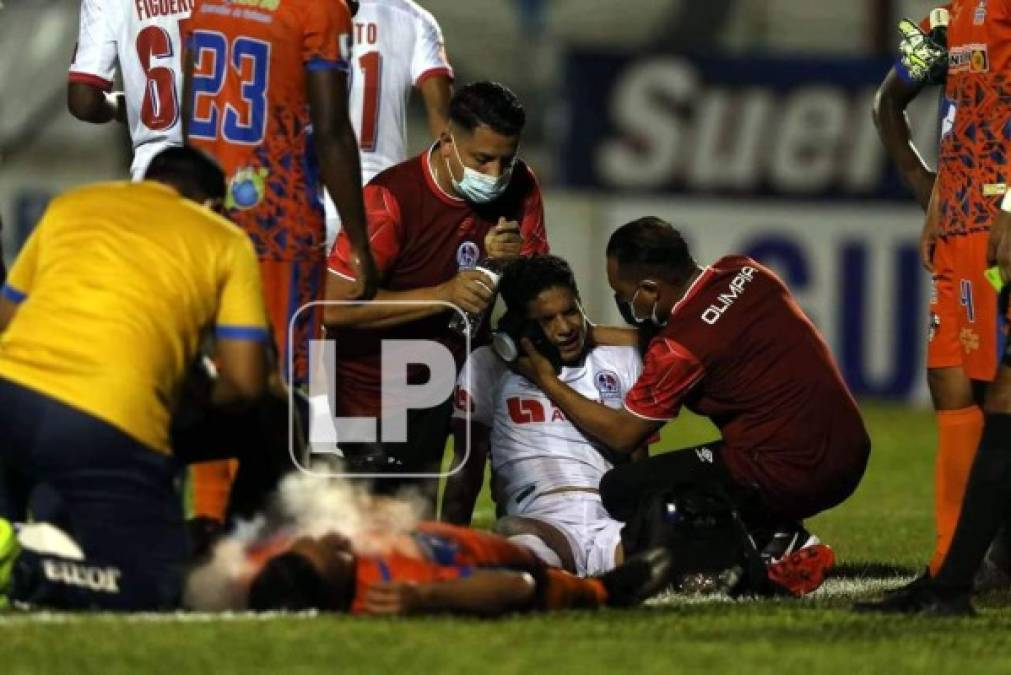 Carlos Pineda, con gestos de dolor en su rostro, recibe atención médica en el campo.