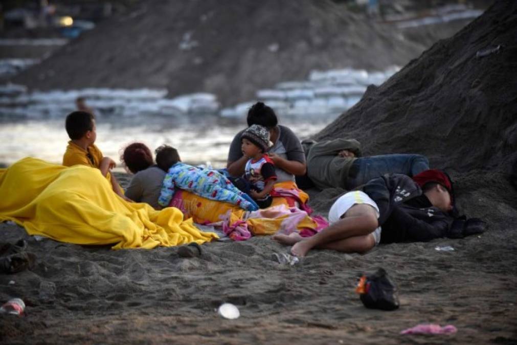 Central American migrants -heading in a caravan for the US- wake up on the bank of the Suichate River, where they spent the night, in Ciudad Hidalgo, Mexico, after crossing from Tecum Uman, Guatemala, on January 21, 2020. - Some 500 Central Americans, from the so-called '2020 Caravan', crossed Monday from Guatemala to Mexico, but over 400 were intercepted when National Guardsmen fired tear gas at them. (Photo by Johan ORDONEZ / AFP)