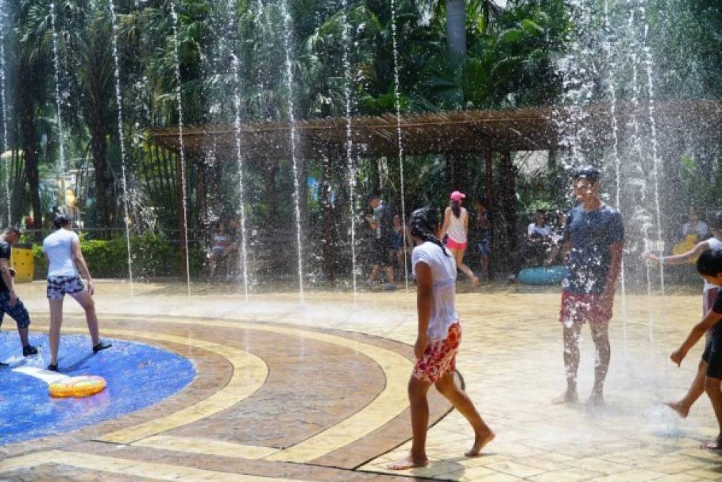 Jóvenes y personas adultas disfrutan de los atractivos que ofrece el parque acuático para los veraneantes.