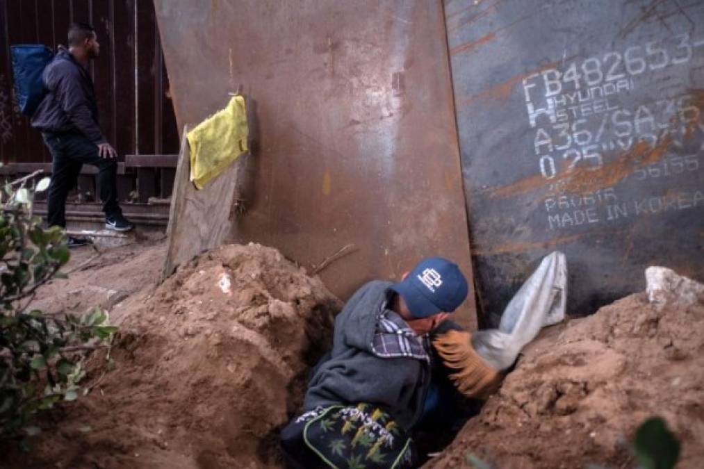 Migrantes hondureños se escabulleron por debajo del muro para cruzar a EEUU y solicitar asilo.