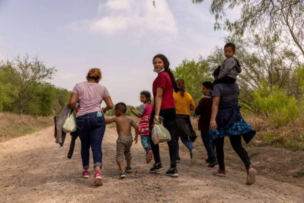 Los solicitantes de asilo de Honduras caminan hacia un puesto de control de la Patrulla Fronteriza de los Estados Unidos después de cruzar el Río Bravo desde México el 23 de marzo de 2021 cerca de Mission, Texas. AFP