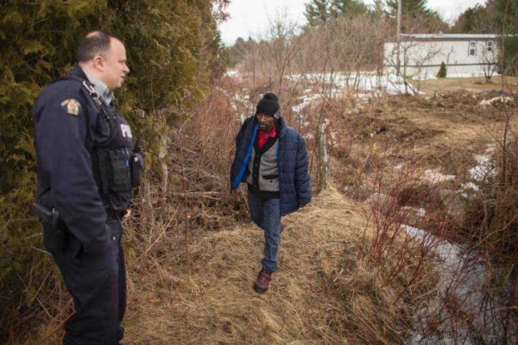 Un hombre de la República del Congo es recibido por un oficial de la patrulla fronteriza tras cruzar ilegalmente de EUA a Quebec.