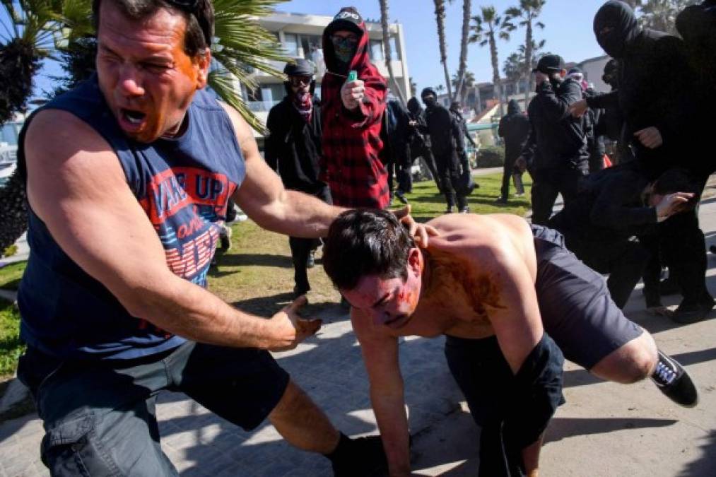 TOPSHOT - Counter-protesters spray pepper spray as they clash with people during a 'Patriot March' demonstration in support of President Trump on January 9, 2021 in the Pacific Beach neighborhood of San Diego, California. (Photo by Patrick T. FALLON / AFP)