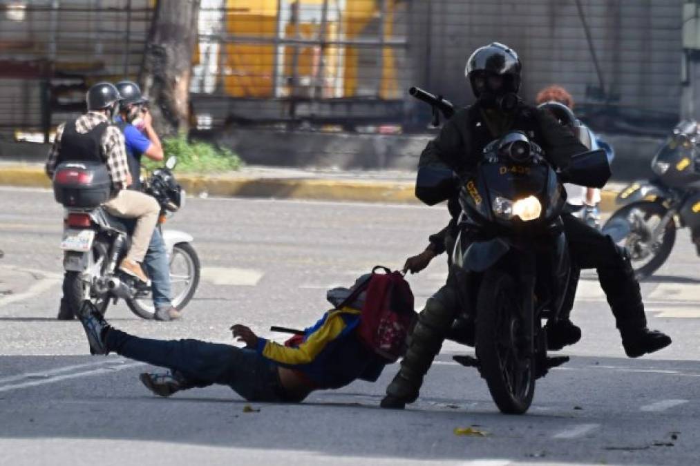 TOPSHOT - Members of the National Guard arrest an opposition activist during a demonstration against the government of Venezuelan President Nicolas Maduro, in Caracas on June 26, 2017.<br/>A political and economic crisis in the oil-producing country has spawned often violent demonstrations by protesters demanding Maduro's resignation and new elections. The unrest has left 75 people dead since April 1.<br/> / AFP PHOTO / Juan BARRETO