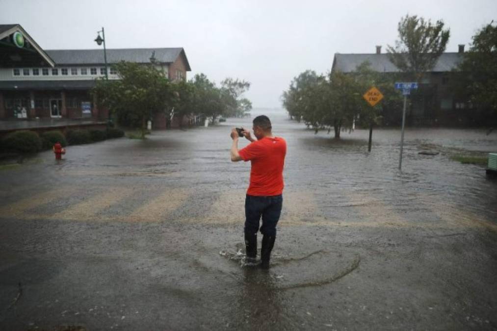 NEW BERN, NC - SEPTEMBER 13: A man makes photographs of the flooded streets as the Neuse River floods its banks during Hurricane Florence September 13, 2018 in New Bern, North Carolina. Coastal cities in North Carolina, South Carolina and Virginia are under evacuation orders as the Category 2 hurricane approaches the United States. Chip Somodevilla/Getty Images/AFP
