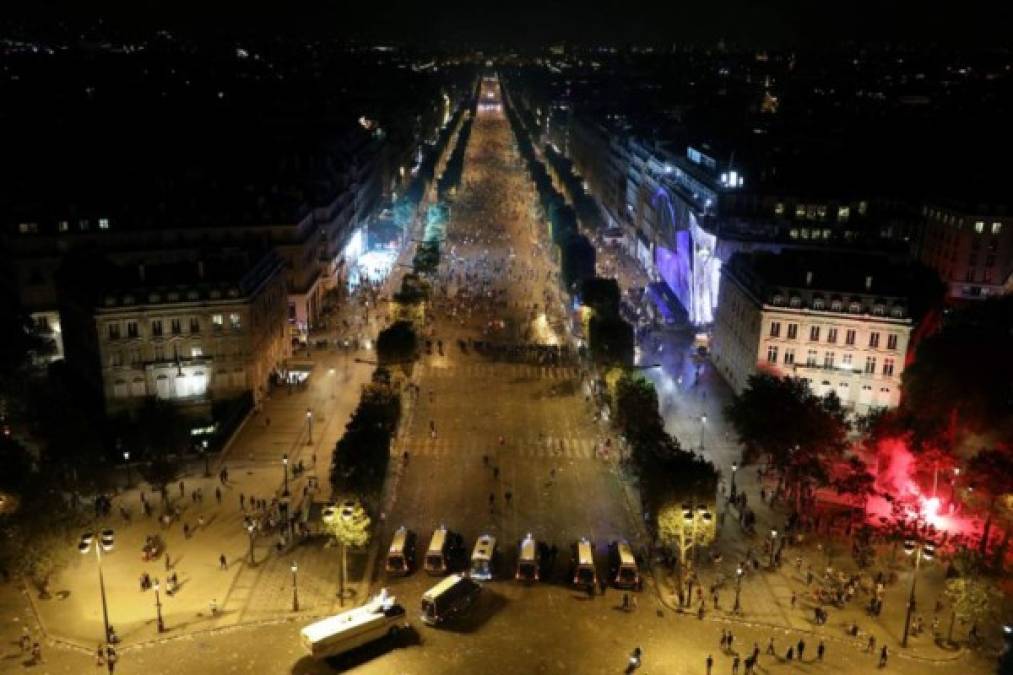 Firefighters extinguish a burning car near the Champs-Elysees in Paris on August 23, 2020, as PSG supporters gather after the UEFA Champions League final football match between Paris Saint-Germain and Bayern Munich at the Luz stadium in Lisbon. - Bayern Munich won the Champions League on August 23, 2020 after a 1-0 victory over Paris Saint-Germain saw the German giants crowned Europe's top team for the sixth time. Kingsley Coman's 59th-minute header ensured Bayern triumphed at the Estadio da Luz in Lisbon and condemned his boyhood club PSG to defeat in their first ever final in the competition (Photo by Sameer Al-DOUMY / AFP)