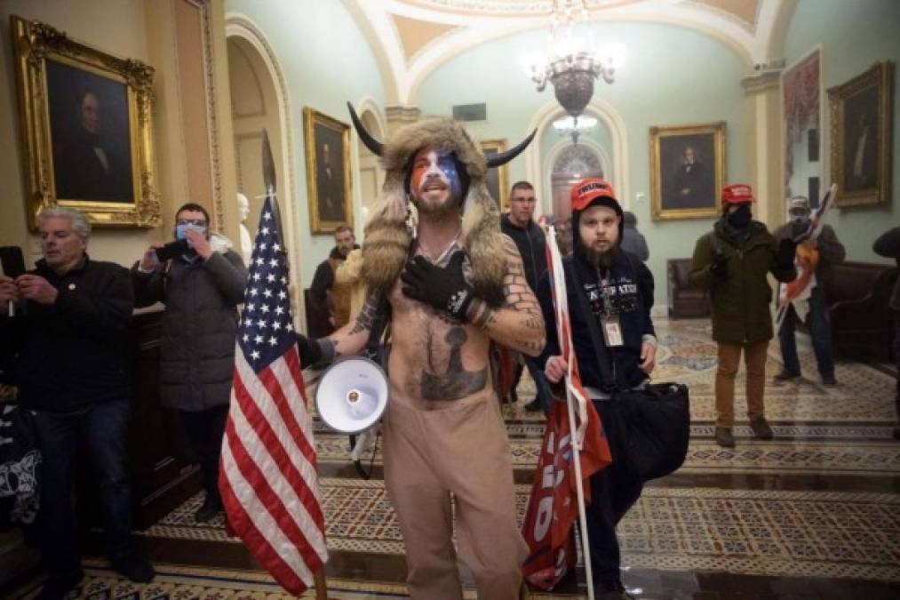 Luego de ingresar al Capitolio con otros manifestantes, en un momento fue visto en el estrado del Senado posando para una foto sosteniendo con su mano izquierda una lanza de la que colgaba una bandera de los Estados Unidos.