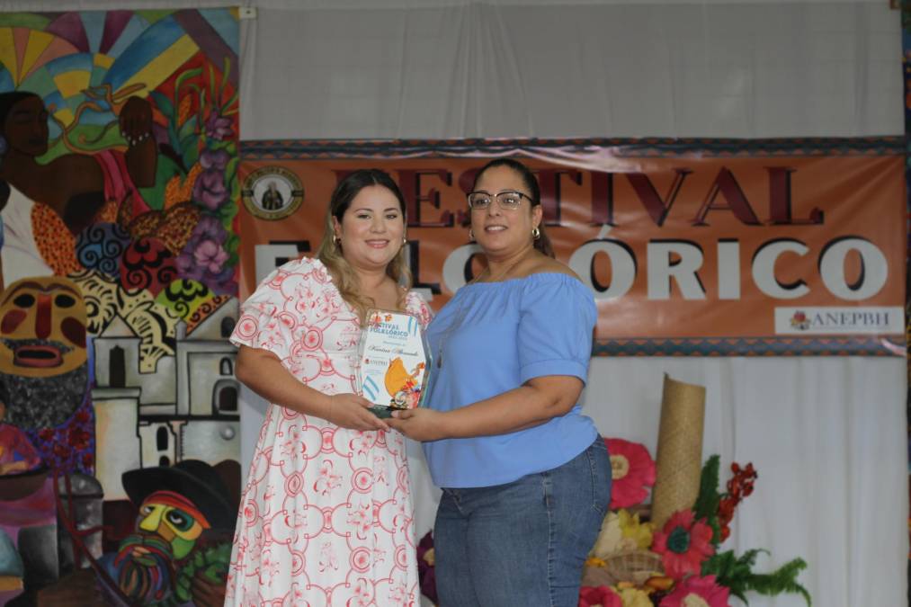 Ana Karina Reyes, hija de la profesora homenajeada Karina Alvarado, al recibir el reconocimiento de su madre. La entrega la realizó Marijosse Sánchez. 