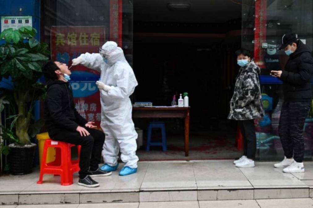 A man wearing a face mask sells duck in his shop in Wuhan, China's central Hubei province on April 14, 2020. - China has largely brought the coronavirus under control within its borders since the outbreak first emerged in the city of Wuhan late last year. (Photo by Hector RETAMAL / AFP)