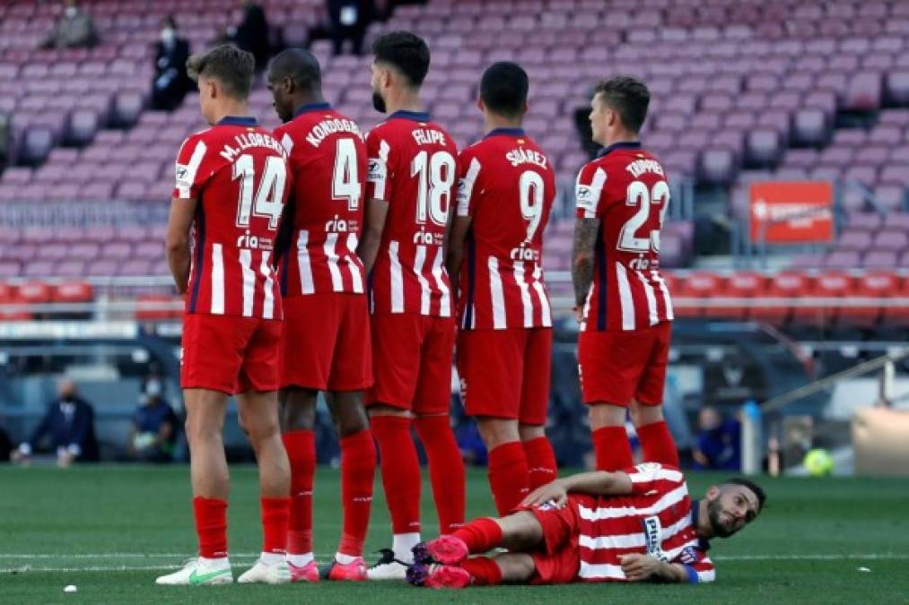 Los jugadores del Atlético de Madrid forman una barrera, mientras que Koke se tira al suelo para intentar bloquear el balón si el tiro libre de Messi iba por bajo.