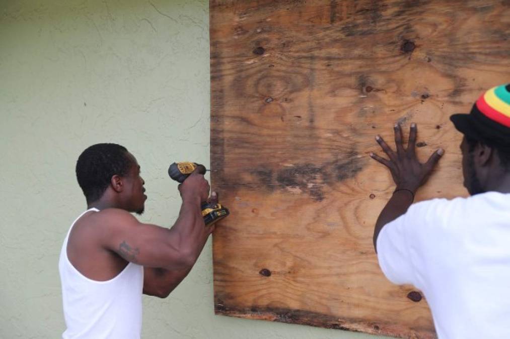 PORT SALERNO, FLORIDA - SEPTEMBER 1: Marcus McClain (L) and Langdon Bryant secure plywood over a window as they protect the home just in case Hurricane Dorian hits the area on September 01, 2019 in Port Salerno, Florida. Dorian was projected to make landfall along the Florida coast but now projections have it making a sharp turn to the north as it closes in on Florida. Joe Raedle/Getty Images/AFP<br/><br/>== FOR NEWSPAPERS, INTERNET, TELCOS & TELEVISION USE ONLY ==<br/><br/>