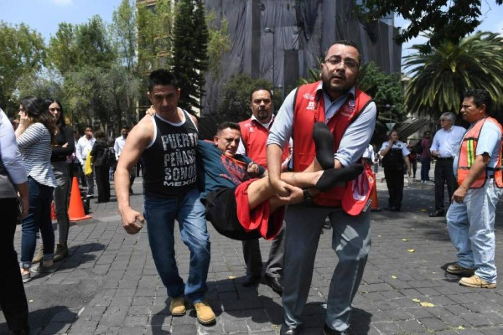 An injured man is carried away by rescuers after a powerful quake in Mexico City on September 19, 2017.<br/>A powerful earthquake shook Mexico City on Tuesday, causing panic among the megalopolis' 20 million inhabitants on the 32nd anniversary of a devastating 1985 quake. The US Geological Survey put the quake's magnitude at 7.1 while Mexico's Seismological Institute said it measured 6.8 on its scale. The institute said the quake's epicenter was seven kilometers west of Chiautla de Tapia, in the neighboring state of Puebla.<br/> / AFP PHOTO / Pedro Pardo