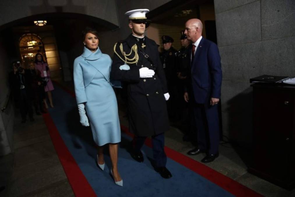 Un infante de marina escolta a la primera dama Melania Trump para ocupar su lugar durante la ceremonia.