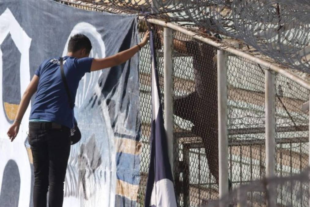 Miembros de la afición del Motagua colocando una manta en apoyo al equipo azul en el estadio Nacional previo al partido contra el Vida.