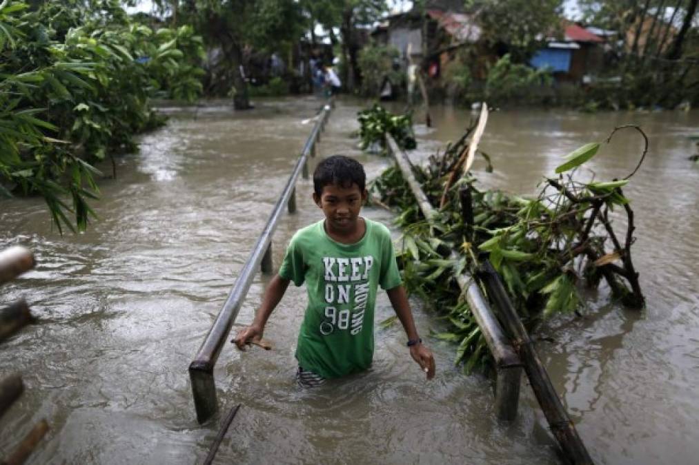 FILIPINAS. Inundados por paso de tifón. Un adolescente es captado en una zona inundada por el paso del tifón Nock-Ten por la localidad de Pamplona, Camarines Sur. Foto: EFE/Francis R. Malasig