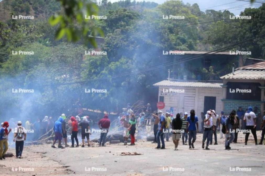 Agentes antimotines lanzaron bombas lacrimógenas para que los manifestantes desbloquearan la calle.