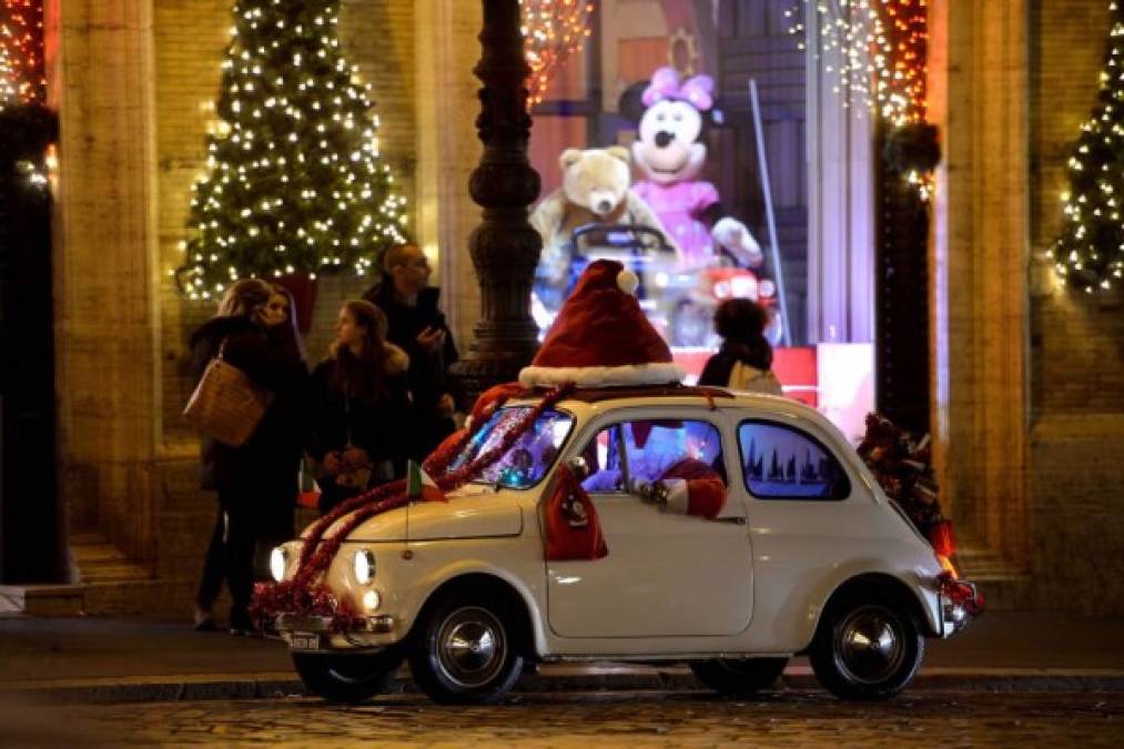 Santa Claus está en todos lados y viaja a bordo de su viejo Fiat 500 en la Piazza Venezia, en Roma.