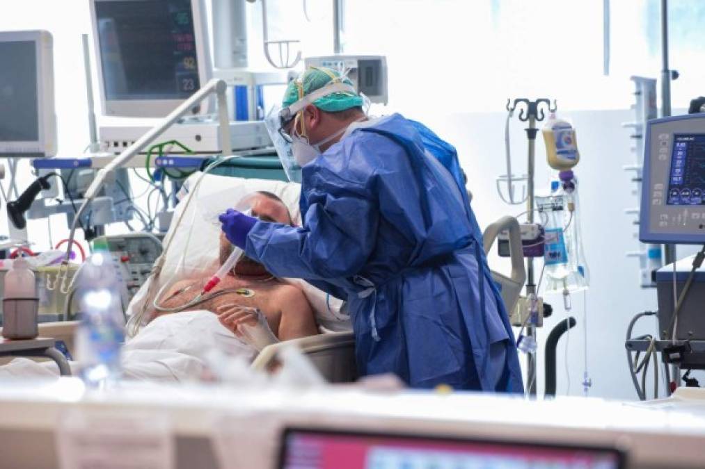 A medical worker wearing a face make and protection gear tends to a patient inside the new coronavirus intensive care unit of the Brescia Poliambulanza hospital, Lombardy, on March 17, 2020. (Photo by Piero CRUCIATTI / AFP)