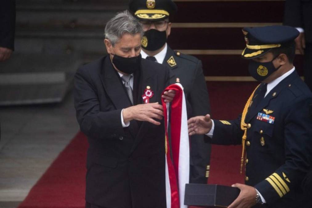 Momento en el que el presidente saliente de Perú, Francisco Sagasti, coloca la banda presidencial en una caja al cierre de su mandato como presidente interino en la entrada del Congreso Nacional, momentos antes de que el presidente electo de Perú, Pedro Castillo, jure en Lima el 28 de julio de 2021. (Foto de Janine Costa / AFP)