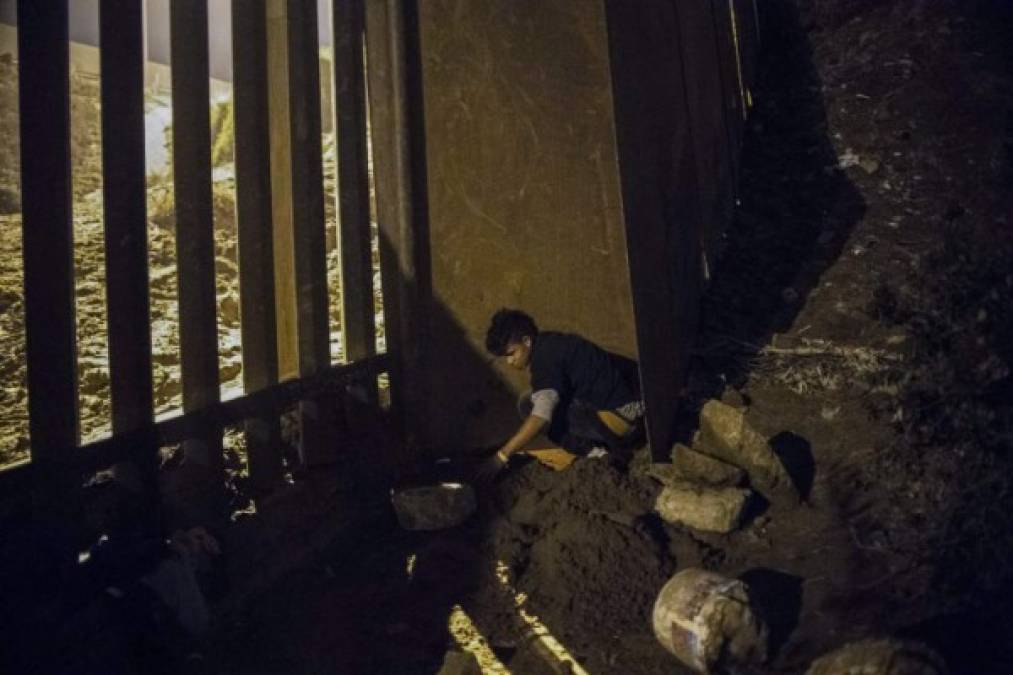 Salvadorean migrant Cesar Jobet, traveling with the third Central American caravan to the US, digs under the US-Mexico border to illegally cross from Playas de Tijuana, Baja California State, Mexico, late November 30, 2018. (Photo by PEDRO PARDO / AFP)