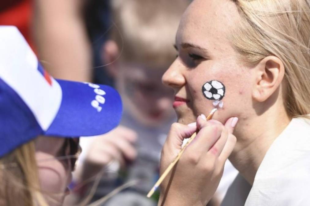 A supporter has a football painted on her face outside the stadium ahead of the Russia 2018 World Cup Group C football match between Denmark and Australia at the Samara Arena in Samara on June 21, 2018. / AFP PHOTO / EMMANUEL DUNAND / RESTRICTED TO EDITORIAL USE - NO MOBILE PUSH ALERTS/DOWNLOADS