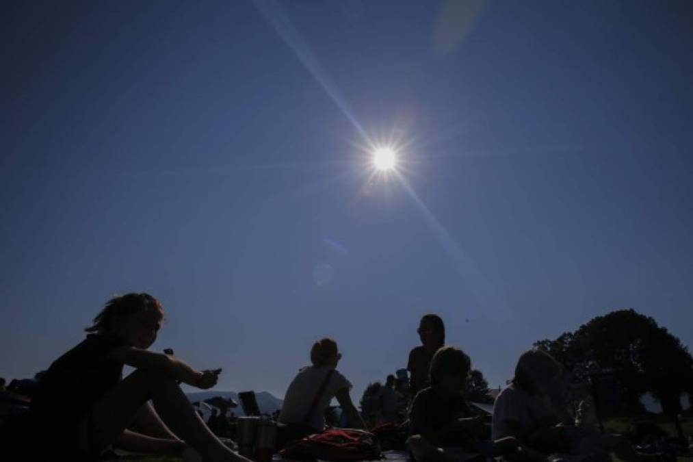 Varias personas disfrutan de los instantes antes de un eclipse solar en Rabun Gap, Georgia. EFE