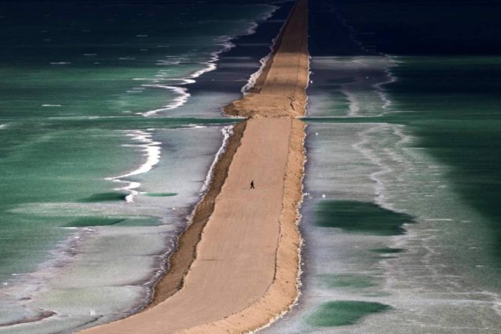 Israel.<br/>Paseo por el mar muerto. Un hombre camina por un brazo de arena en el Mar Muerto, cerca de Ein Bokek.