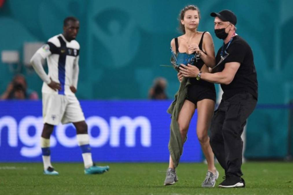 Una chica ha sorprendido en la jornada de este lunes en la Eurocopa al invadir el terreno de las acciones en el duelo Finlandia vs Bélgica. Fotos AFP y EFE.