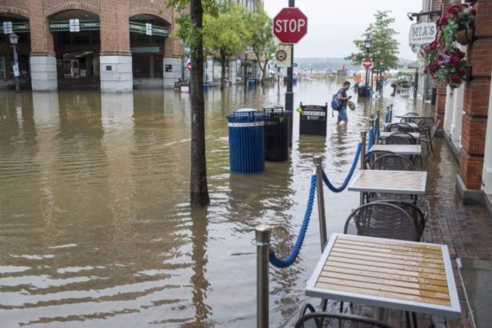 A man walks as rainwater floods outside buildings in Old Town Alexandria, Virginia on September 11, 2018,as sandbags were being distributed to businesses and residents in preparation before more rain arrives from Hurricane Florence. <br/>More than a million people were under evacuation orders in the eastern United States Tuesday, where powerful Hurricane Florence threatened catastrophic damage to a region popular with vacationers and home to crucial government institutions. / AFP PHOTO / ZACH GIBSON