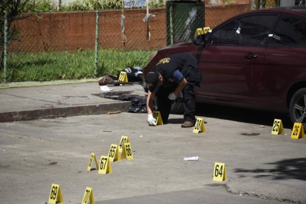 Forensic personnel work on the place where the body of a prison guard shot dead by presumed gang members lies covered by a plastic sheet, outside the Roosevelt Hospital, in Guatemala City on August 16,2017.<br/>At least four people were killed and several others wounded when presumed gang members shot dead two prison guards and seriously wounded a third in Guatemala City, raising the toll of policemen killed so far this year to 24, authorities said. Two civilians, including an eight-year-old child, were also killed in the crossfire and several more wounded. / AFP PHOTO / JOHAN ORDONEZ