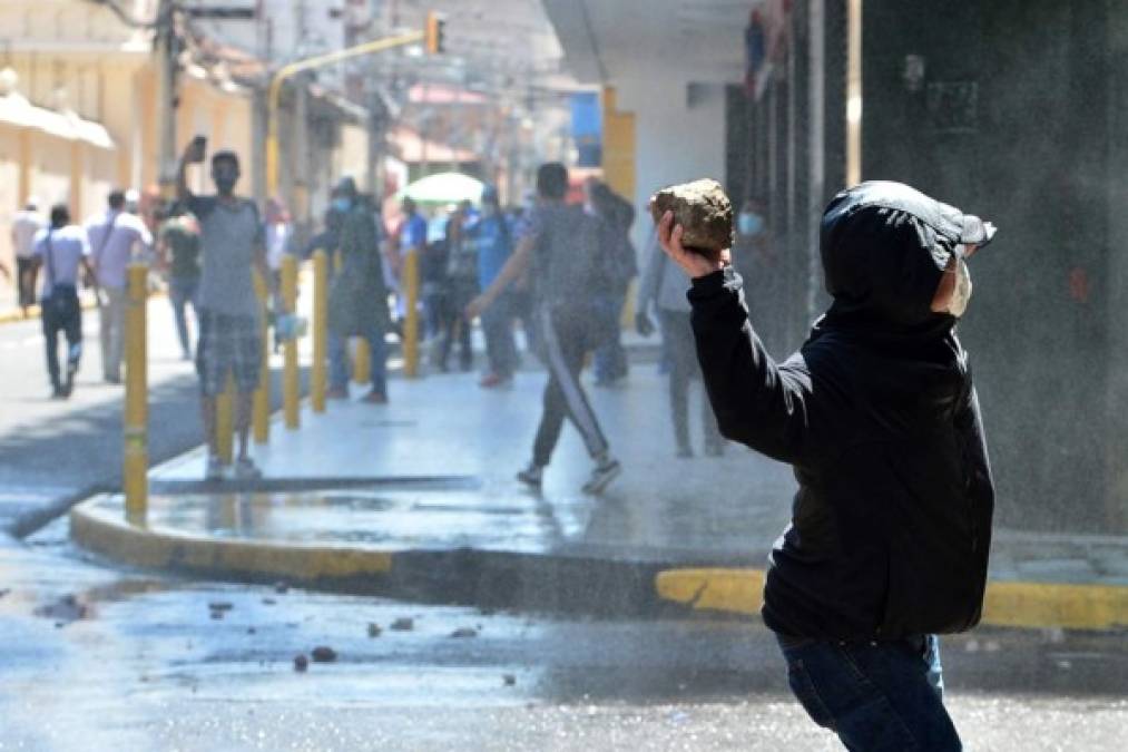 Los manifestantes respondieron las bombas lacrimógenas lanzando piedras a los policías.