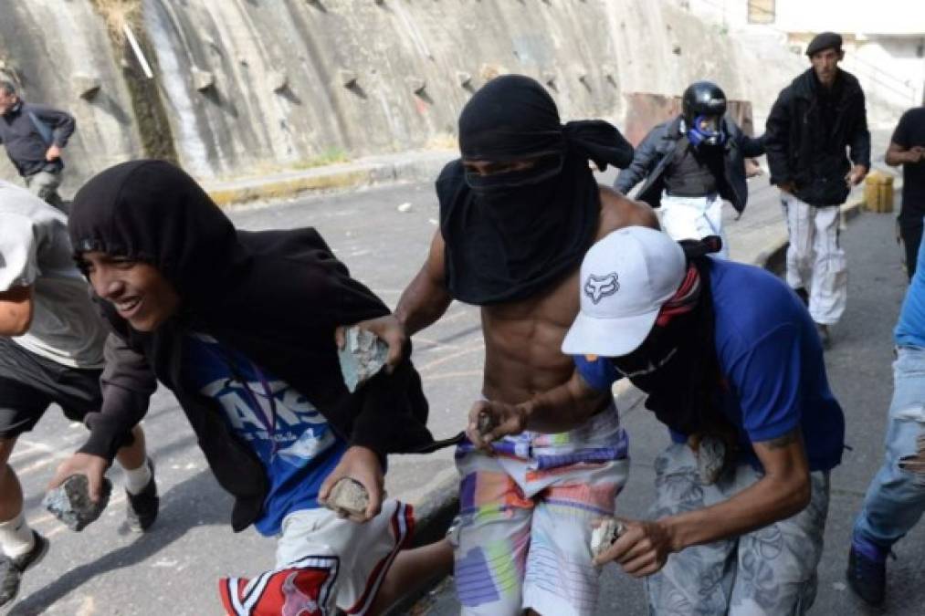 Anti-government demonstrators clash with police and troops in the surroundings of a National Guard command post in Cotiza, in northern Caracas, on January 21, 2019. - A group of soldiers rose up against Venezuela's President Nicolas Maduro at a command post in northern Caracas on Monday, but were quickly arrested after posting an appeal for public support in a video, the government said. (Photo by Federico PARRA / AFP)