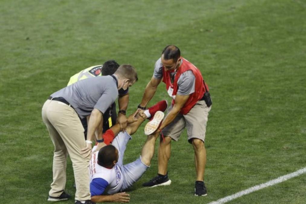 Entre varios tuvieron que capturar al aficionado del Olimpia para sacarlo del campo.