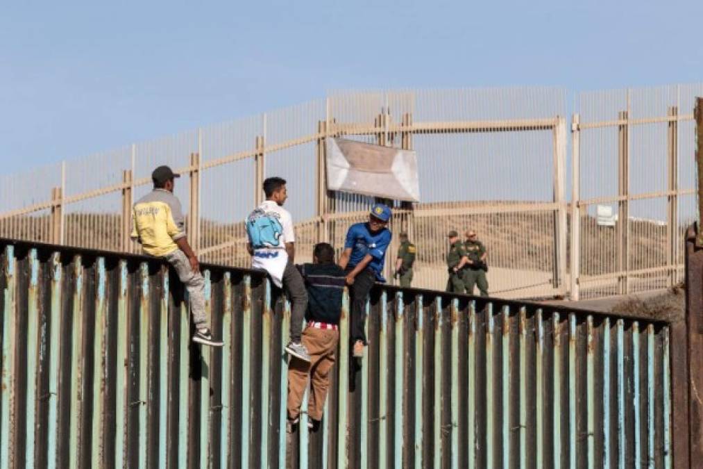 Cientos de migrantes centroamericanos alcanzaron hoy la frontera México-Estados Unidos y treparon la valla que divide ambos países desafiando a los agentes de la Patrulla Fronteriza y al presidente estadounidense, Donald Trump.<br/>