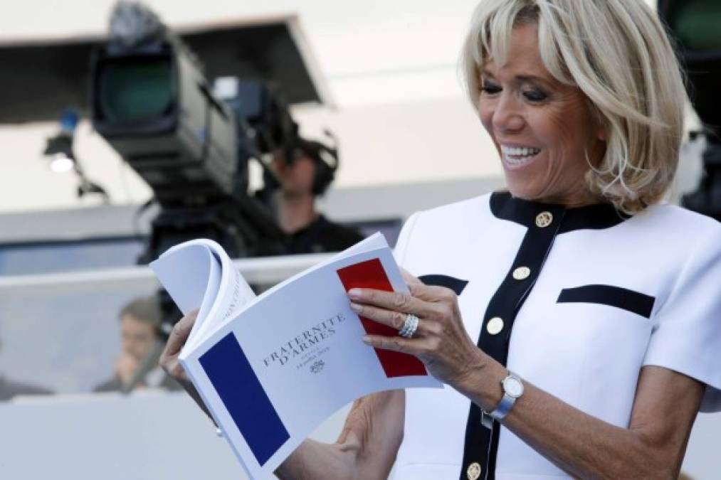Brigitte Macron, wife of French President, looks at the program booklet before the traditional Bastille Day military parade on the Champs-Elysees avenue in Paris, on July 14, 2018. / AFP PHOTO / POOL / PHILIPPE WOJAZER