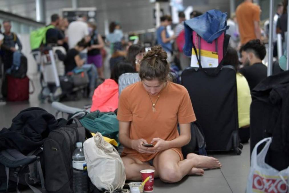 Los pasajeros varados permanecen en el aeropuerto internacional El Dorado en Bogotá. En Colombia bloquearán todos los vuelos internacionales desde el lunes durante 30 días para evitar la propagación del coronavirus, COVID-19, anunció el jueves el presidente Ivan Duque. Foto AFP