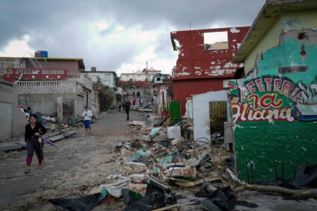 Residents of tornado-hit Regla neighbourhood walk amid the debris, in Havana, on January 28, 2019. - A rare and powerful tornado that struck Havana killed three people and left 172 injured, Cuban President Miguel Diaz-Canel said early Monday. (Photo by ADALBERTO ROQUE / AFP)