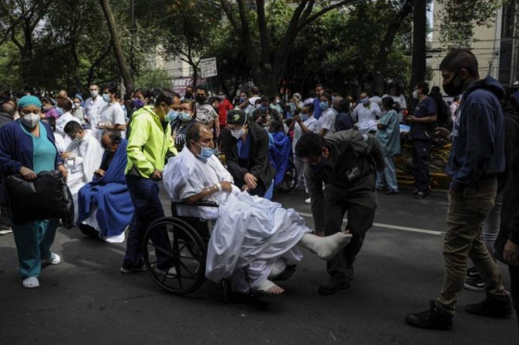 People remain outside the Durango clinic in Mexico City during a quake on June 23, 2020 amid the COVID-19 novel coronavirus pandemic. - A 7.1 magnitude quake was registered Tuesday in the south of Mexico, according to the Mexican National Seismological Service. (Photo by CLAUDIO CRUZ / AFP)