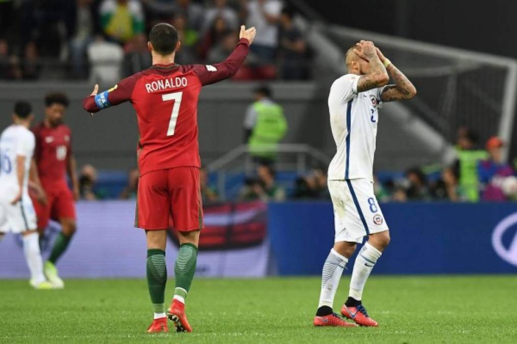 Portugal's forward Cristiano Ronaldo (L) gestures as Chile's midfielder Arturo Vidal reacts after missing a goal during the 2017 Confederations Cup semi-final football match between Portugal and Chile at the Kazan Arena in Kazan on June 28, 2017. / AFP PHOTO / FRANCK FIFE