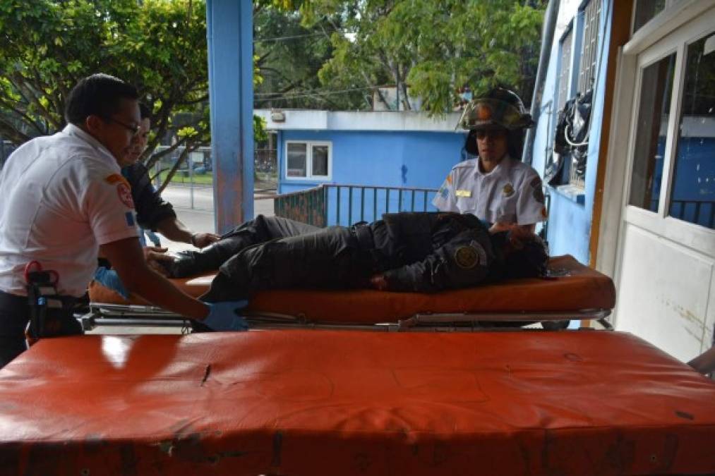 GU3016. CIUDAD DE GUATEMALA (GUATEMALA), 18/08/2017. Un guardia penitenciario herido es atendido por un grupo de bomberos luego de un ataque armado al Hospital Roosevelt hoy, miércoles 16 de agosto de 2017, en Ciudad de Guatemala (Guatemala). El terror se apoderó hoy del Hospital Roosevelt, uno de los principales de la capital de Guatemala, cuando pandilleros atacaron con fusiles el lugar para liberar a uno de sus compañeros, que logró huir, y dejaron seis muertos y doce heridos. EFE/Esteban Biba // ATENCIÓN EDITORES: CONTENIDO GRÁFICO EXPLÍCITO