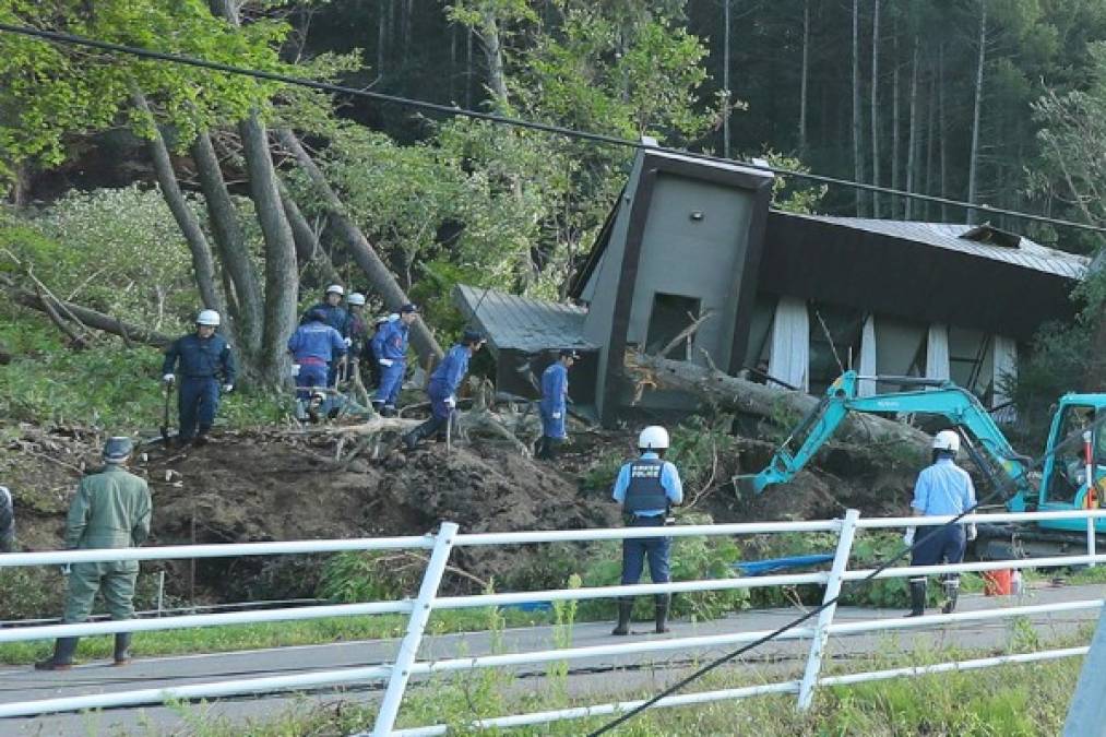 Police and rescue workers search for survivors from a house that was damaged by a landslide caused by an earthquake in Atsuma town in Hokkaido prefecture on September 6, 2018.<br/>A powerful 6.6 magnitude quake hit the northern Japanese island of Hokkaido on September 6, triggering landslides, bringing down several houses, and killing at least one person with several dozen missing. / AFP PHOTO / JIJI PRESS / JIJI PRESS / Japan OUT