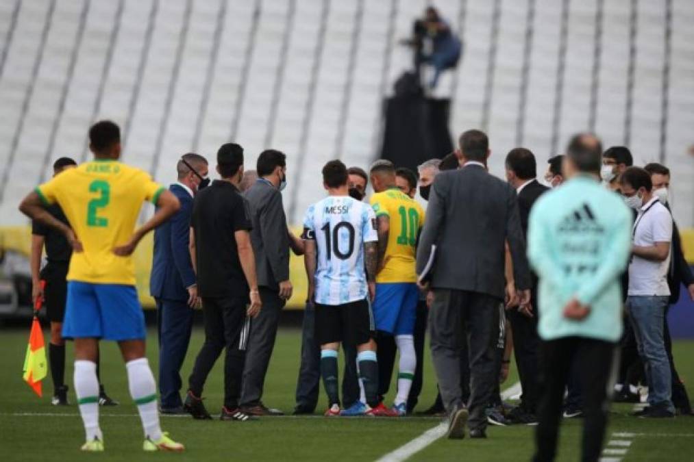 Neymar y Messi hablan con funcionarios de salud brasileños en pleno campo tras ser interrumpido el partido.