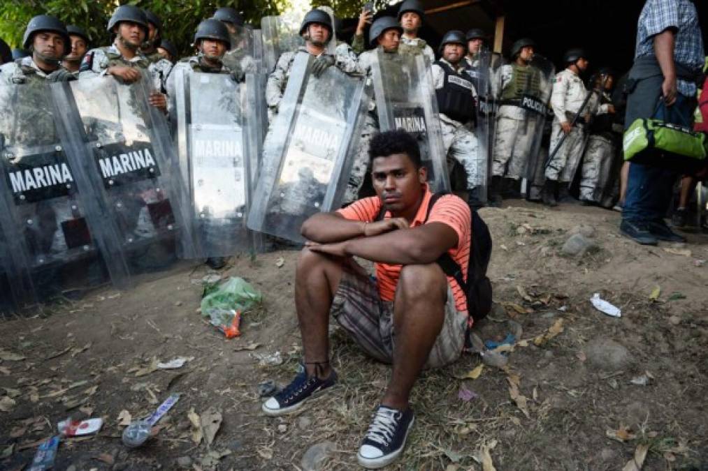 A Central American migrant - heading in a caravan to the US - reacts as members of Mexican National Guard prevent them from continuing walking in Ciudad Hidalgo, Chiapas State, Mexico, on January 23, 2020. - Hundreds of Central American migrants surged into Mexico Thursday, wading unopposed across a river on the Guatemalan border where Mexican troops had used tear gas earlier in the week to keep them back, AFP journalists at the scene reported. (Photo by ALFREDO ESTRELLA / AFP)