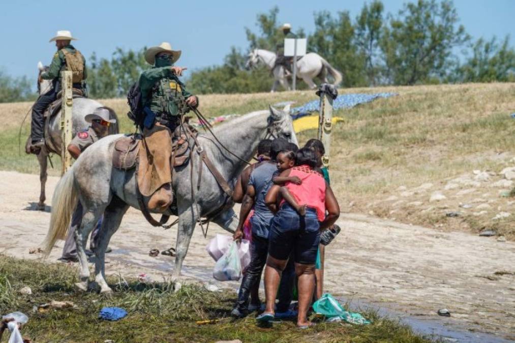 A United States Border Patrol agent on horseback tries to stop Haitian migrants from entering an encampment on the banks of the Rio Grande near the Acuna Del Rio International Bridge in Del Rio, Texas on September 19, 2021. - US law enforcement are attempting to close off crossing points along the Rio Grande river where migrants cross to get food and water, which is scarce in the encampment. The United States said Saturday it would ramp up deportation flights for thousands of migrants who flooded into the Texas border city of Del Rio, as authorities scramble to alleviate a burgeoning crisis for President Joe Biden's administration. (Photo by PAUL RATJE / AFP)