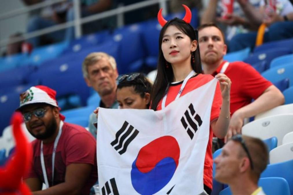 Esta bella fan coreana estuvo apoyando a su selección la bandera y su belleza. Foto AFP