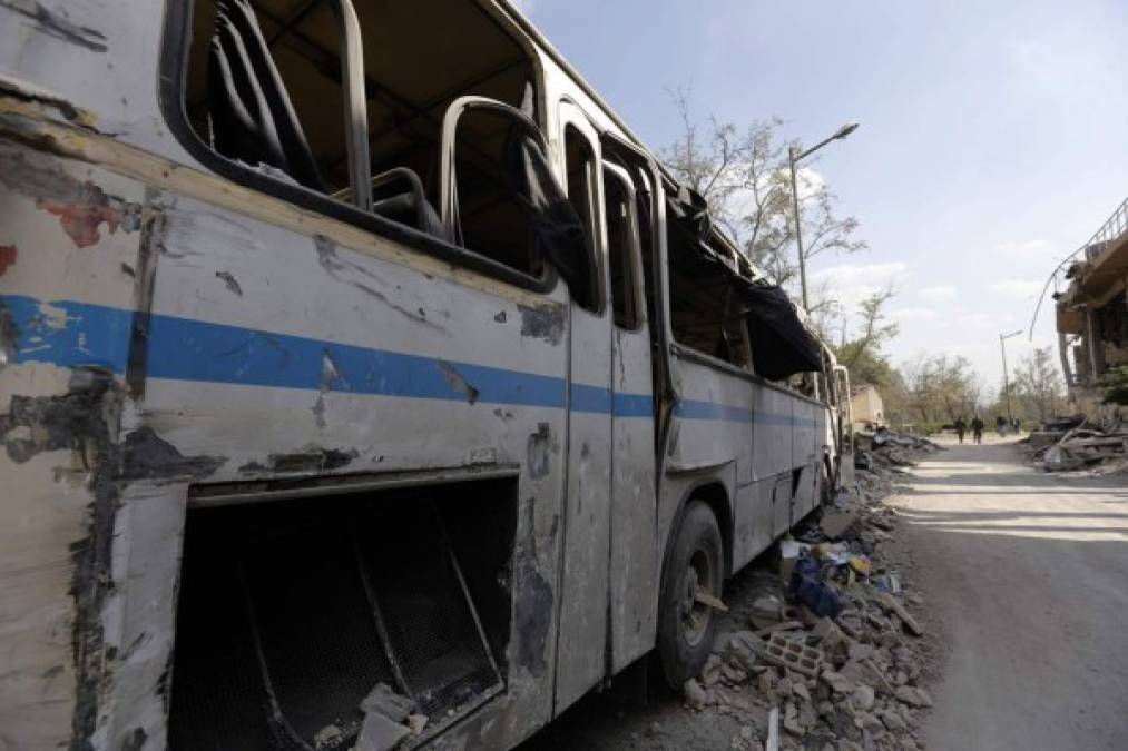 un autobús destruido cerca del edificio del complejo del Centro de Estudios Científicos (SSRC), ubicado en Damasco.